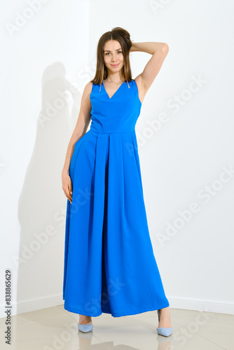 Young fashion model posing in modern blue dress and stilettos