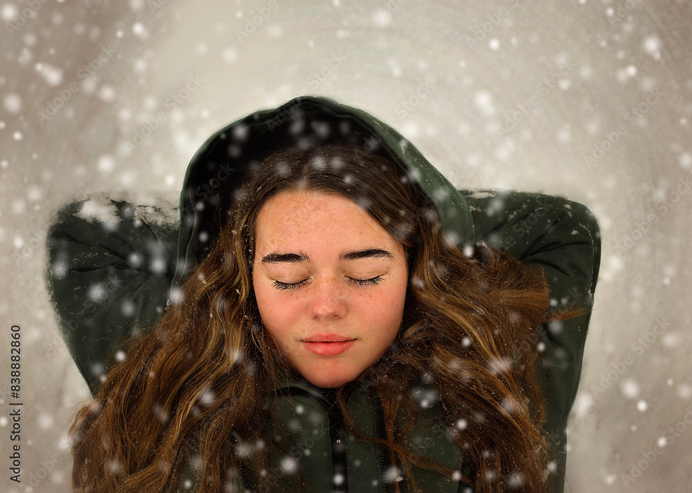 Beautiful teen girl laying with closed eyes in falling snow Beautiful teen girl laying with closed eyes in falling snow