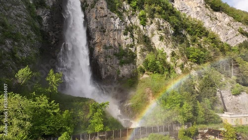 Breathtaking view of Seerenbach Falls near Amden Betlis, Switzerland with vibrant rainbow and surrounding lush greenery. photo