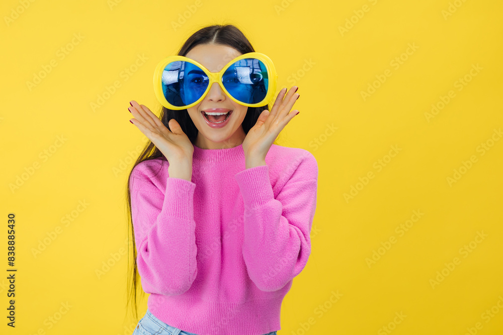 cute lovely girl wear stylish clothes and party sunglasses look camera isolated on yellow color background cute lovely girl wear stylish clothes and party sunglasses look camera isolated on yellow color background