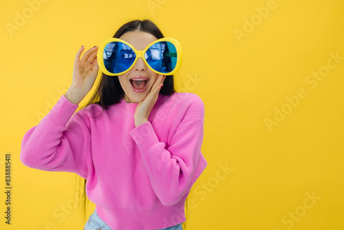 stunning adorable nice woman wear trendy pink clothes posing in sunglasses isolated on yellow color background © Ivan