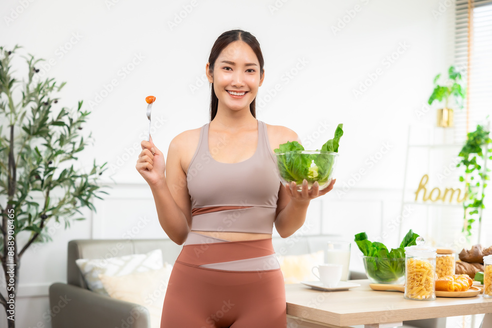 Attractive fitness asian woman finishing workout and drinking protein milk shake vitamins and vegetable after training at home. Bodybuilding. Healthy lifestyle. Attractive fitness asian woman finishing workout and drinking protein milk shake vitamins and vegetable after training at home. Bodybuilding. Healthy lifestyle.