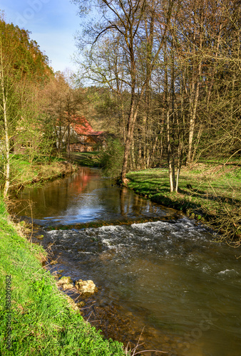 Romantischer Flusslauf mit kleiner Staustufe und rotem Haus in der Fr  nkischen Schweiz  Deutschland