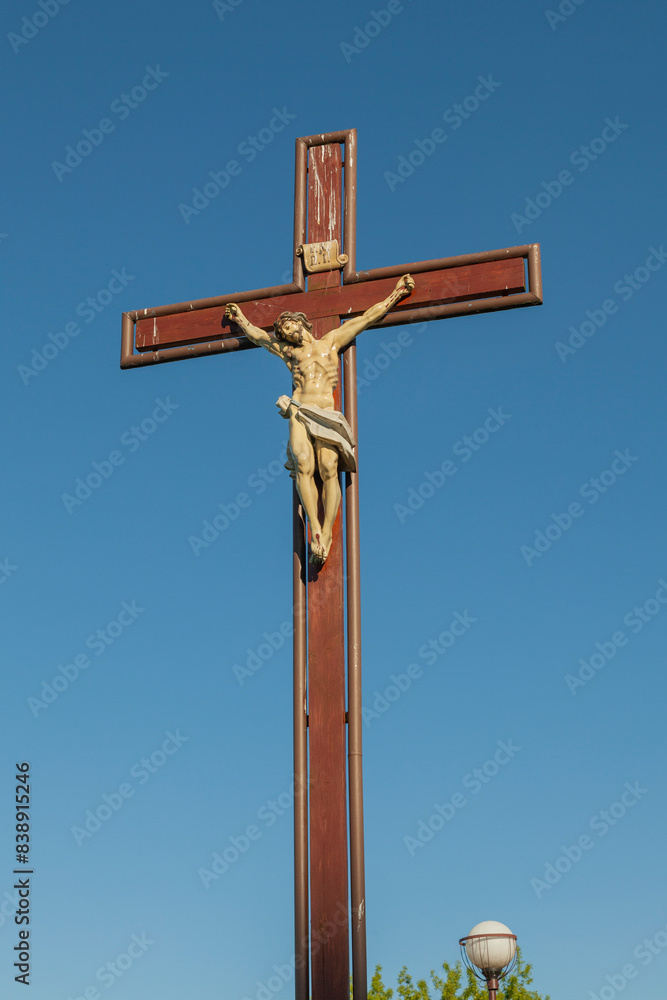 Cross with the crucifixion of Jesus Christ against the blue sky Cross with the crucifixion of Jesus Christ against the blue sky