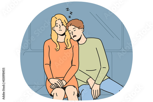Subway passenger sleeps on shoulder of woman embarrassed by tactlessness of unfamiliar guy invading personal space. Man and girl, tired at work, ride in subway car or ground electric train