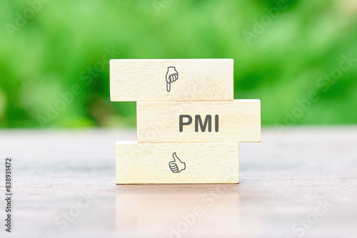 Business concept for companies. Project Management Institute. The text PMI on wooden bars on a table on a green background photo
