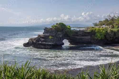 Rocky cliffs by the ocean with crashing waves photo