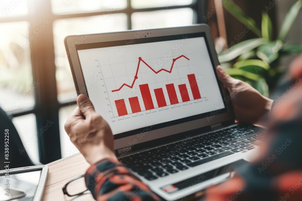 Investment strategy planning. Businessperson hands use a laptop with arrows graphically displayed on an upward growth screen, analyzing financial growth charts, and business planning. Investment strategy planning. Businessperson hands use a laptop with arrows graphically displayed on an upward growth screen, analyzing financial growth charts, and business planning.