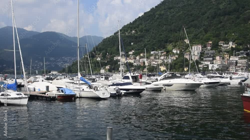 Lake Como. Italy. Yachts and boats sway on the water, moored at the pier. Popular tourist destination. Lake Como. Italy. Yachts and boats sway on the water, moored at the pier. Popular tourist destination.