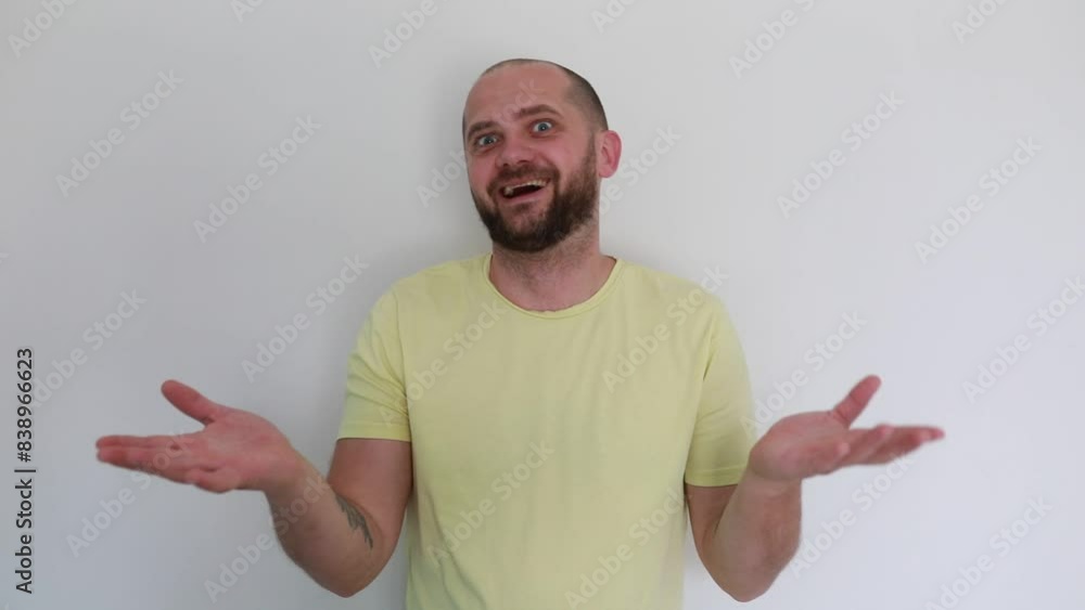 Excited Man in Yellow Shirt Expressing Surprise and Delight Against White Background Excited Man in Yellow Shirt Expressing Surprise and Delight Against White Background