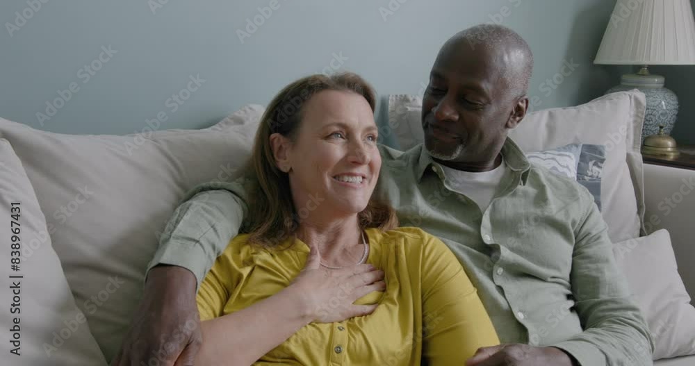 Senior Carefree Couple Laughing together at Home Embracing on the Sofa Senior Carefree Couple Laughing together at Home Embracing on the Sofa