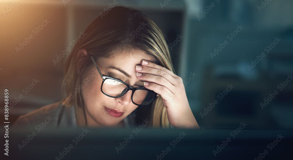 Stress, headache and woman in office at night for web development deadline with mistake or crisis. Burnout, dark and female coder with migraine by computer working overtime on project in workplace.