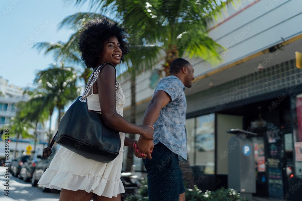 USA, Florida, Miami Beach, happy young couple crossing the street