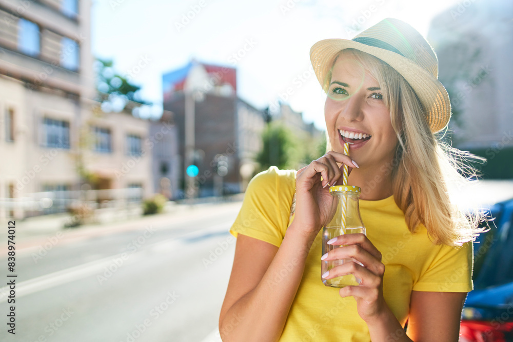 Happy young woman enjoying a drink in the city