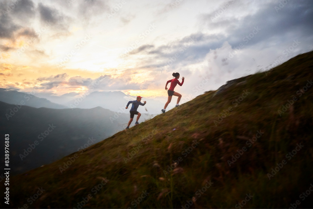 Man and woman running uphill in the mountains Man and woman running uphill in the mountains