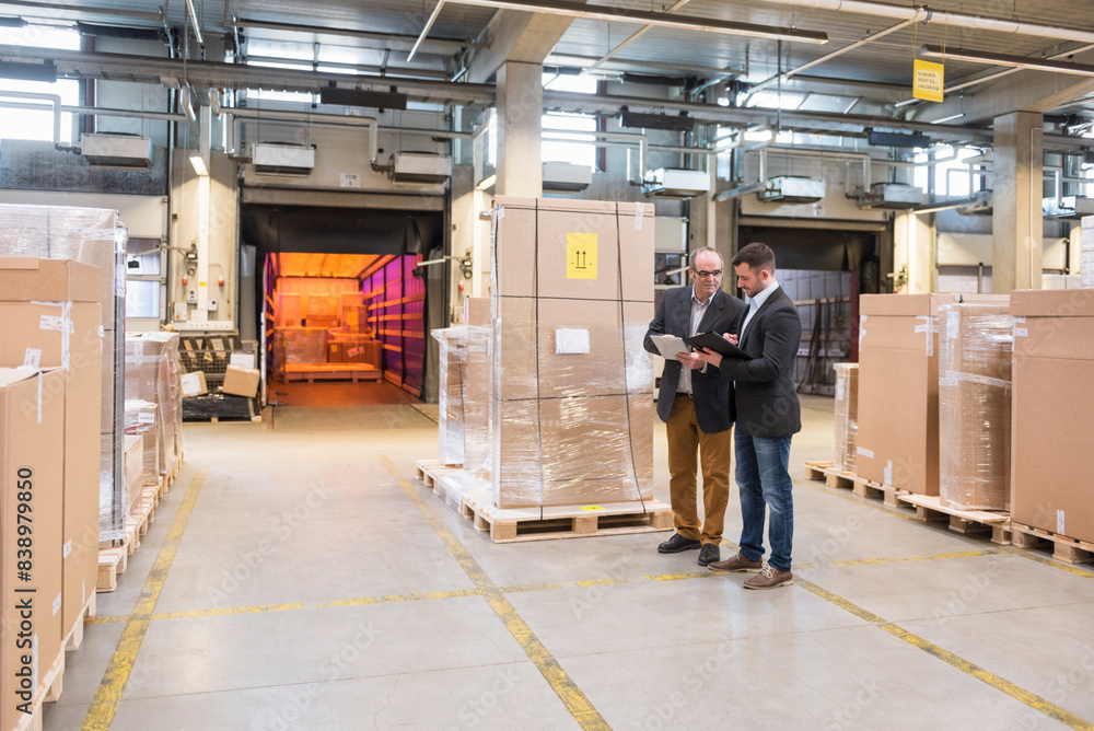 Two men talking in factory warehouse