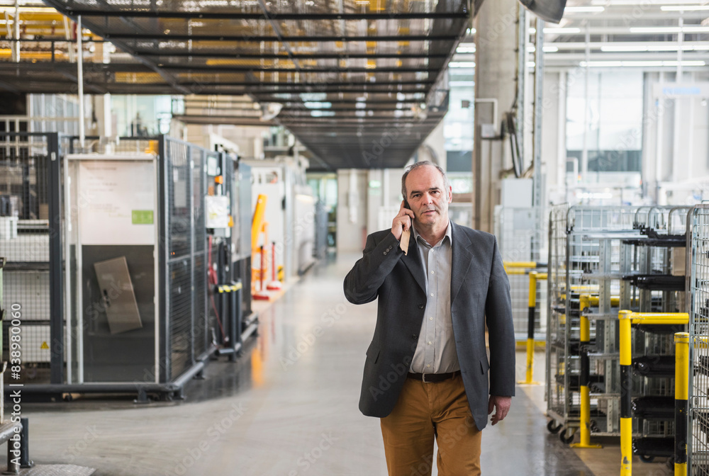 Businessman in factory shop floor talking on the phone