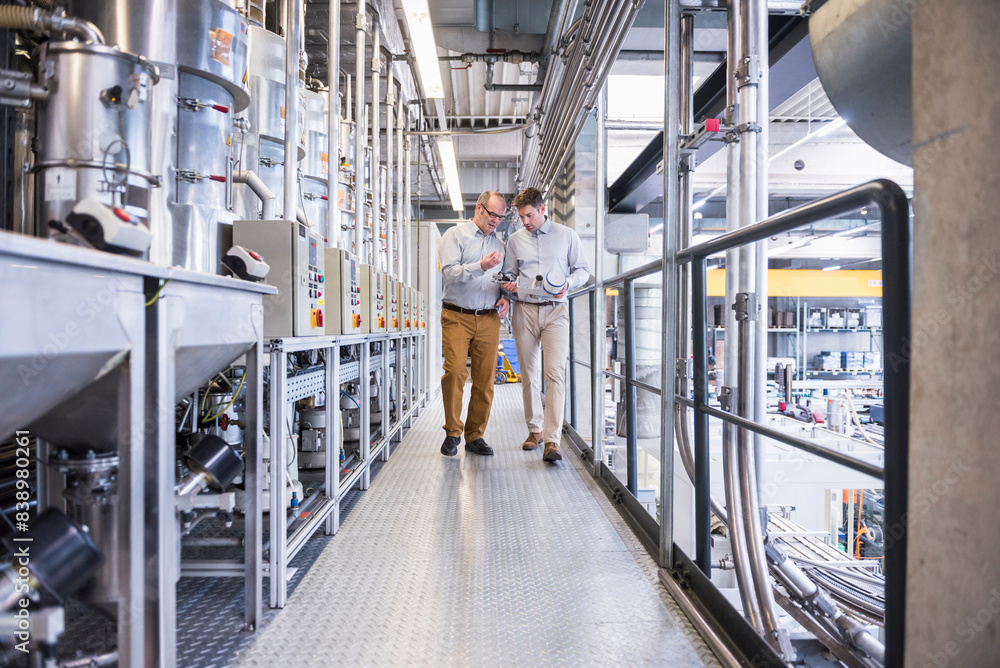 Two men in factory shop floor talking about product