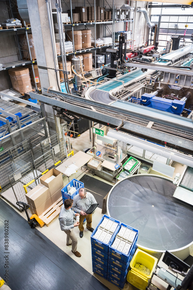 Top view of two men talking in factory shop floor Top view of two men talking in factory shop floor