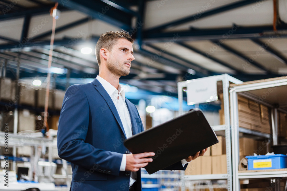 Portrait of a young manager in the shop floor, holding file Portrait of a young manager in the shop floor, holding file