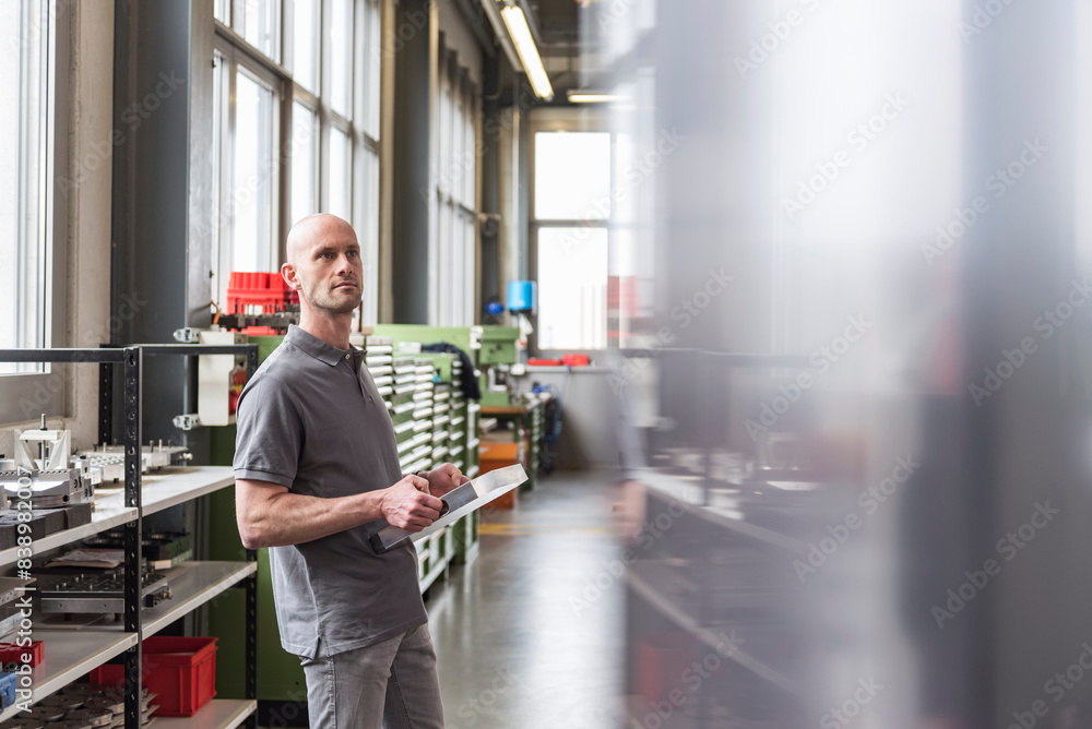 Man standing in modern factory holding product