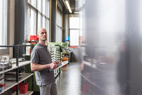 Obraz na płótnie Man standing in modern factory holding product w salonie