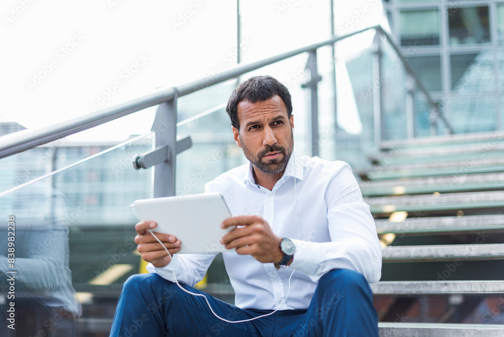 Businessman using tablet, earphone Businessman using tablet, earphone