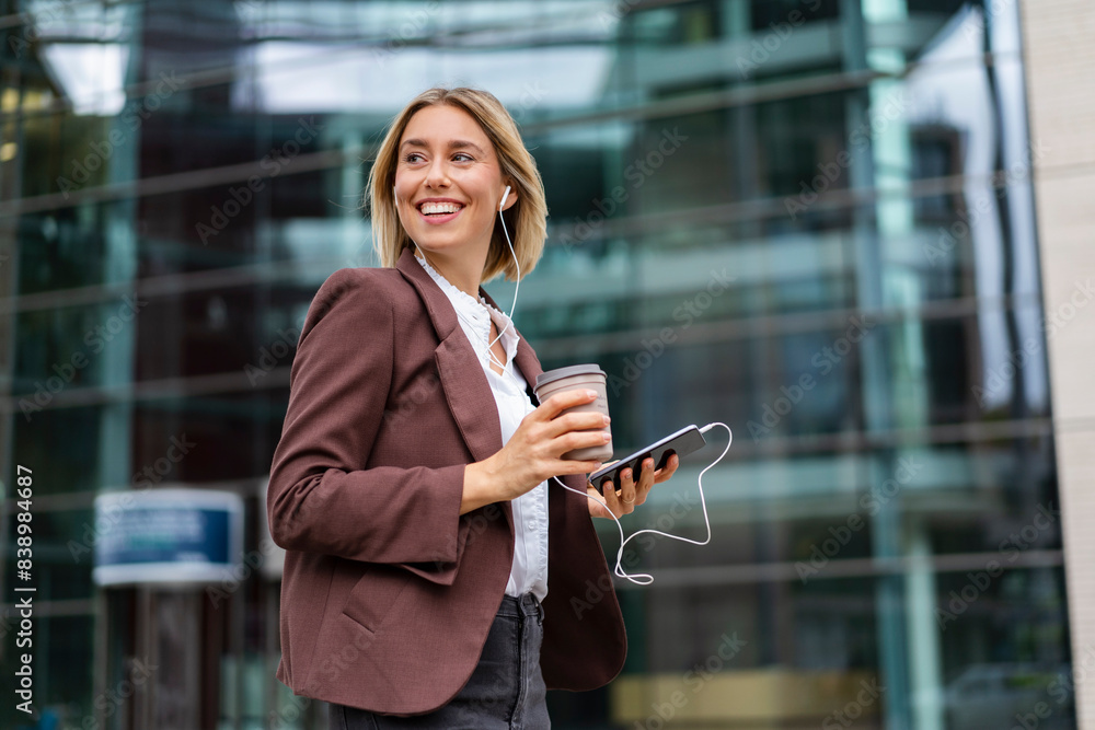 Happy young businesswoman in the city on the go