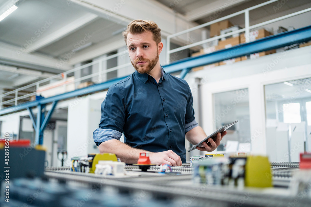 Young man using a tablet in a factory