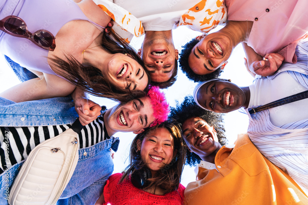 Obraz premium Multiethnic group of young happy friends hanging out in the city - Multiracial group of students meeting and having fun outdoors, concepts about youth, teenage, diversity and lifestyle