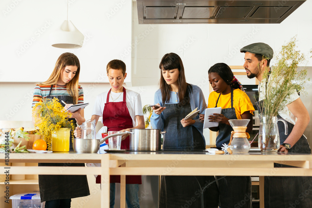 Friends in a cooking workshop listening to instructor