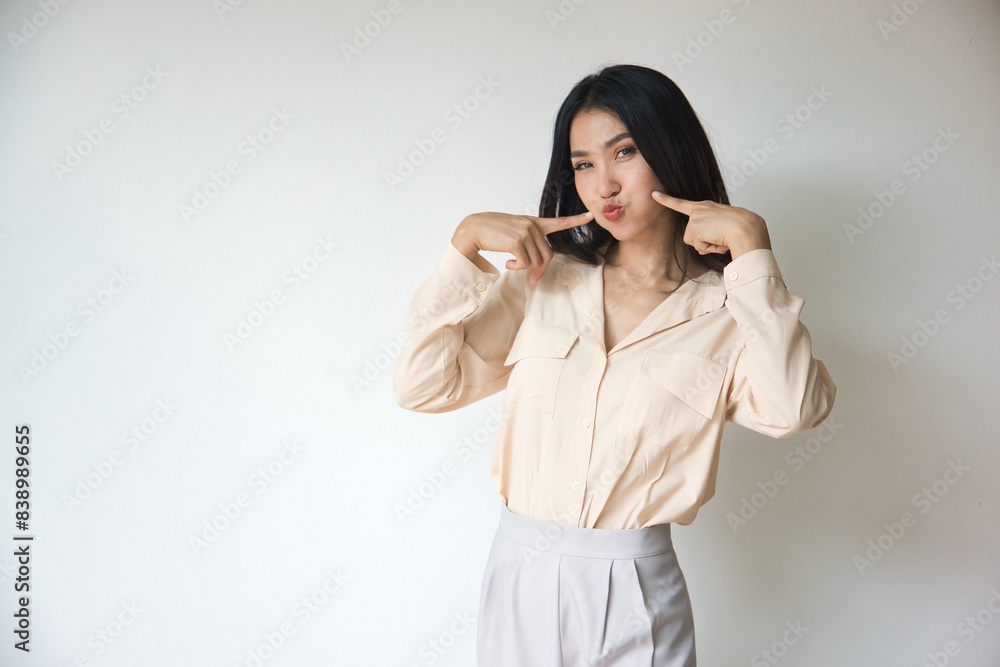 Friendly playful happy smiling Asian young woman in smart casual office worker outfits on isolated background, cute Asian face pointing pose Friendly playful happy smiling Asian young woman in smart casual office worker outfits on isolated background, cute Asian face pointing pose