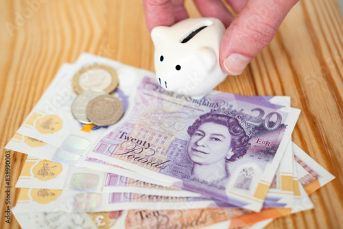 male hands holding piggy bank, English pound sterling bills, pence, Financial responsibility, financial planning, wealth management, economic awareness