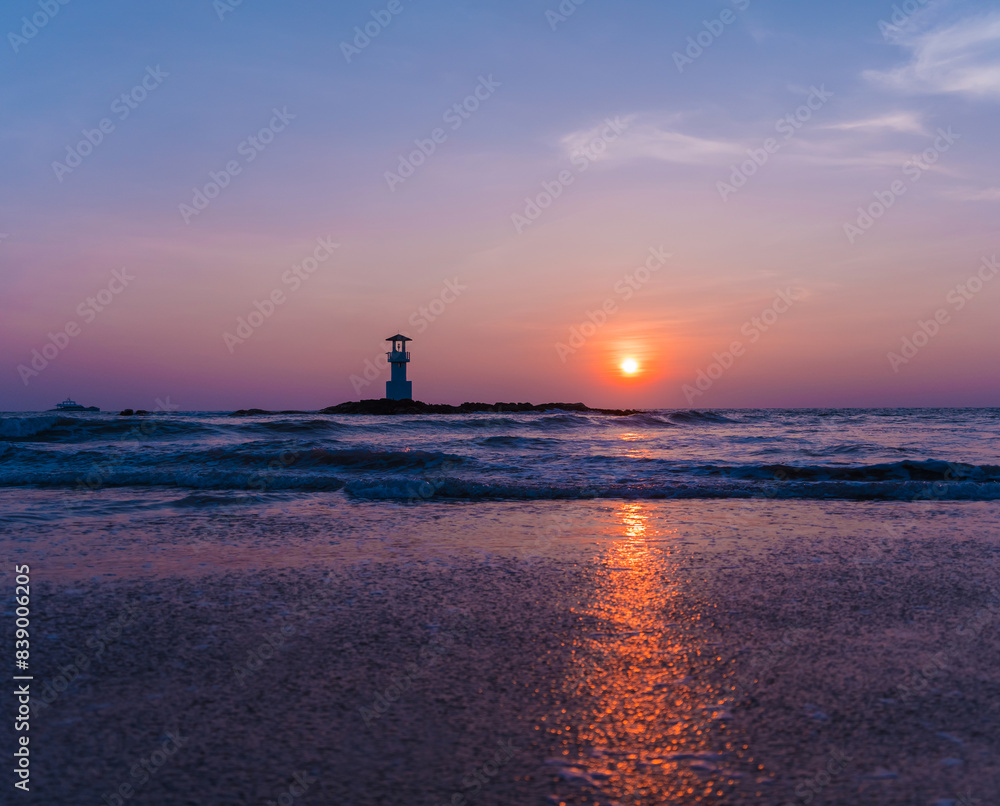 A lighthouse in the ocean during a beautiful sunset