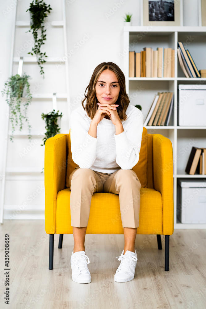 Smiling businesswoman sitting with head in hands on sofa at office Smiling businesswoman sitting with head in hands on sofa at office