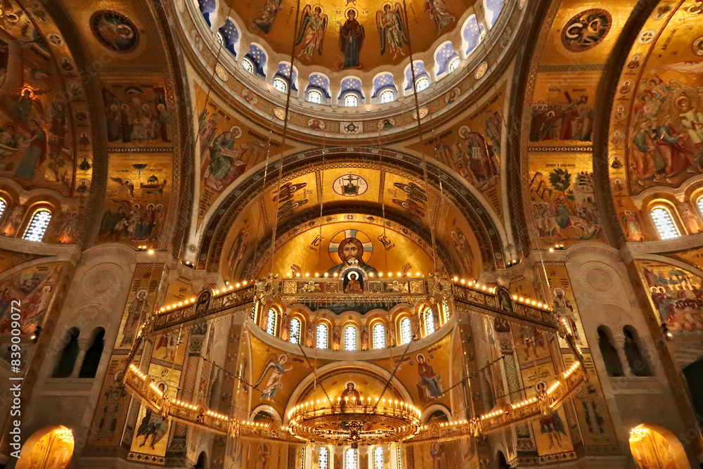 Obraz premium The interior of the Church of Saint, St. Sava, a big golden Chandelier in front of golden walls, vaults, ceiling covered in mosaics, Belgrade, Serbia