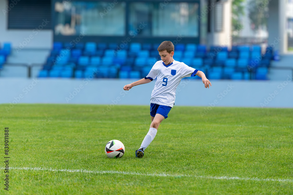 oung soccer player shooting a ball on a modern football stadium. Perfect for sports, youth, fitness, and athletic content. Ideal for promoting energetic and active lifestyles oung soccer player shooting a ball on a modern football stadium. Perfect for sports, youth, fitness, and athletic content. Ideal for promoting energetic and active lifestyles