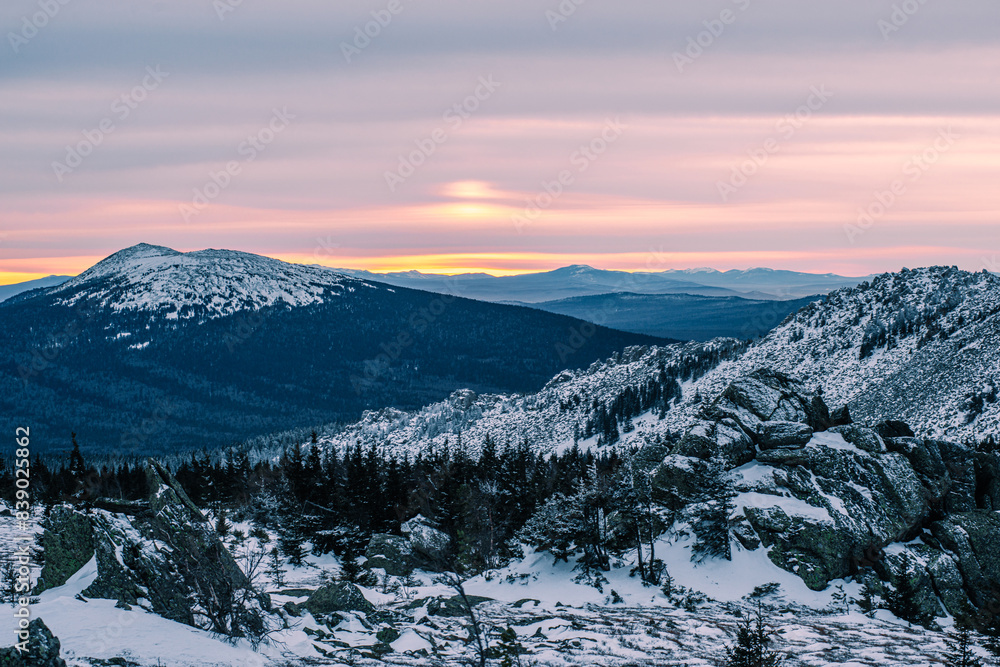 Obraz premium a beautiful pink sunset in the winter snow-capped mountains of the Urals