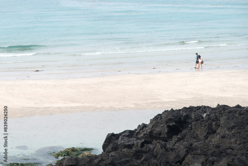 View of the tourists walking on the sand beach View of the tourists walking on the sand beach