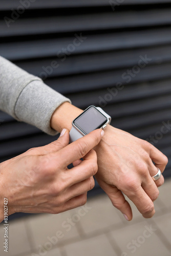 Woman's hand adjusting settings of smartwatch, close-up