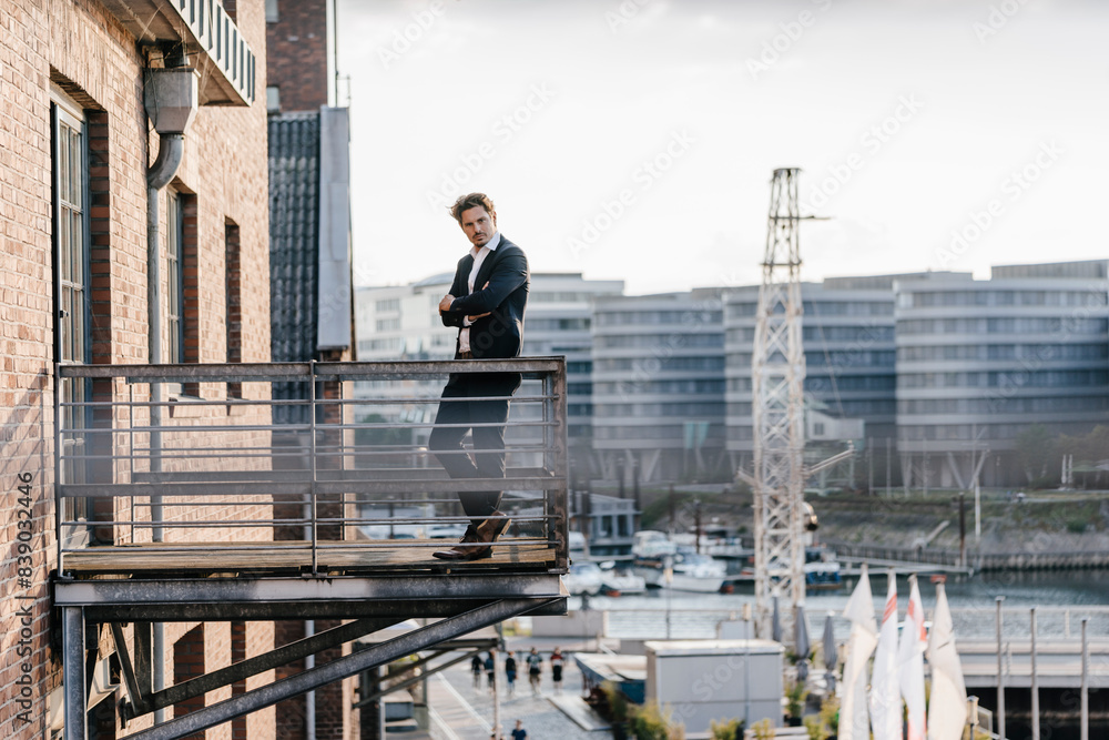 Pensive businessman standing on balcony Pensive businessman standing on balcony