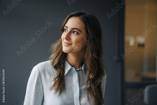 Portrait of smiling young businesswoman looking sideways