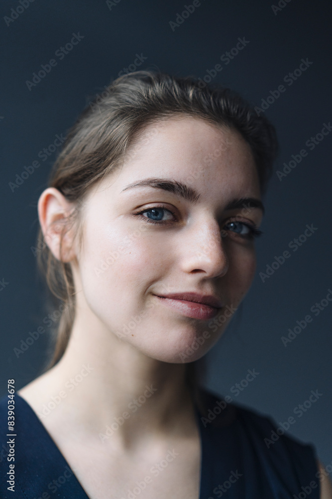 Portrait of smiling young woman against grey background Portrait of smiling young woman against grey background