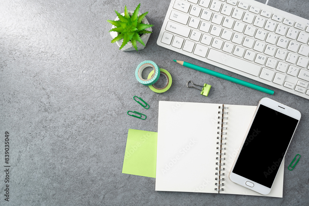 Keyboard and notebook and phone on stone texture background. Work desk space Keyboard and notebook and phone on stone texture background. Work desk space