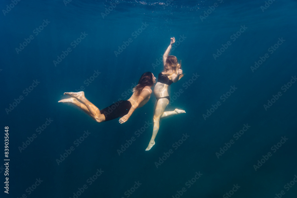 Young couple under water, woman pregnant Young couple under water, woman pregnant