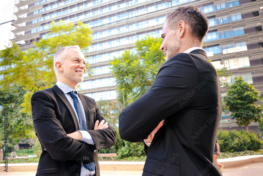 Two happy colleagues face each other, look seriously work as a team, ready to start a new project, pose outdoors Two happy colleagues face each other, look seriously work as a team, ready to start a new project, pose outdoors