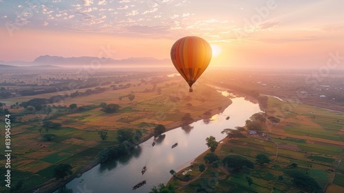 A breathtaking hot air balloon ride over patchwork fields and meandering rivers, with the golden light of sunrise painting the landscape in soft hues of pink and orange.
