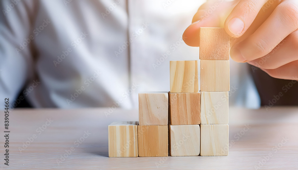 Person Building a Wooden Block Structure on a Table Person Building a Wooden Block Structure on a Table