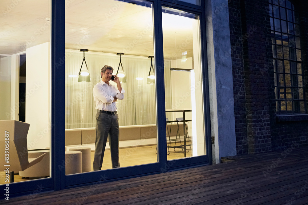 Exterior view of man using smartphone in modern building at night Exterior view of man using smartphone in modern building at night