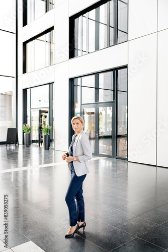 Successful businesswoman standing in entrance hall of office building